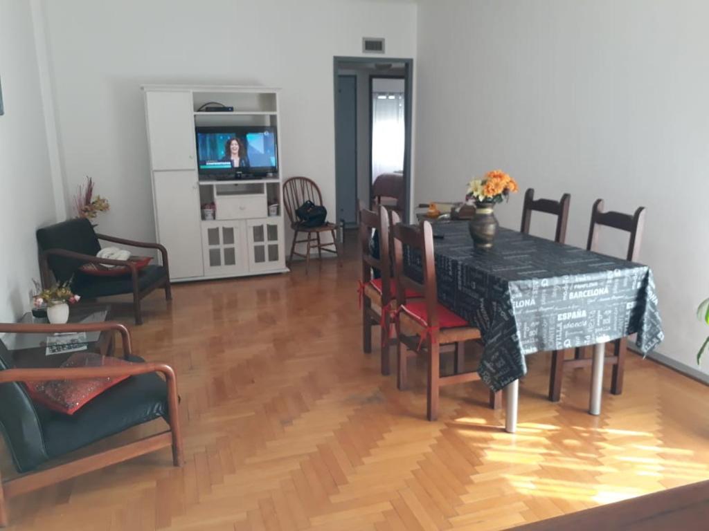 sala de estar con mesa, sillas y TV en Apartamento Lautaro en Buenos Aires