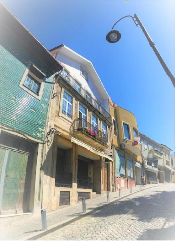 a building on the side of a street with a street light at casa largo do cruzeiro in Peso da Régua