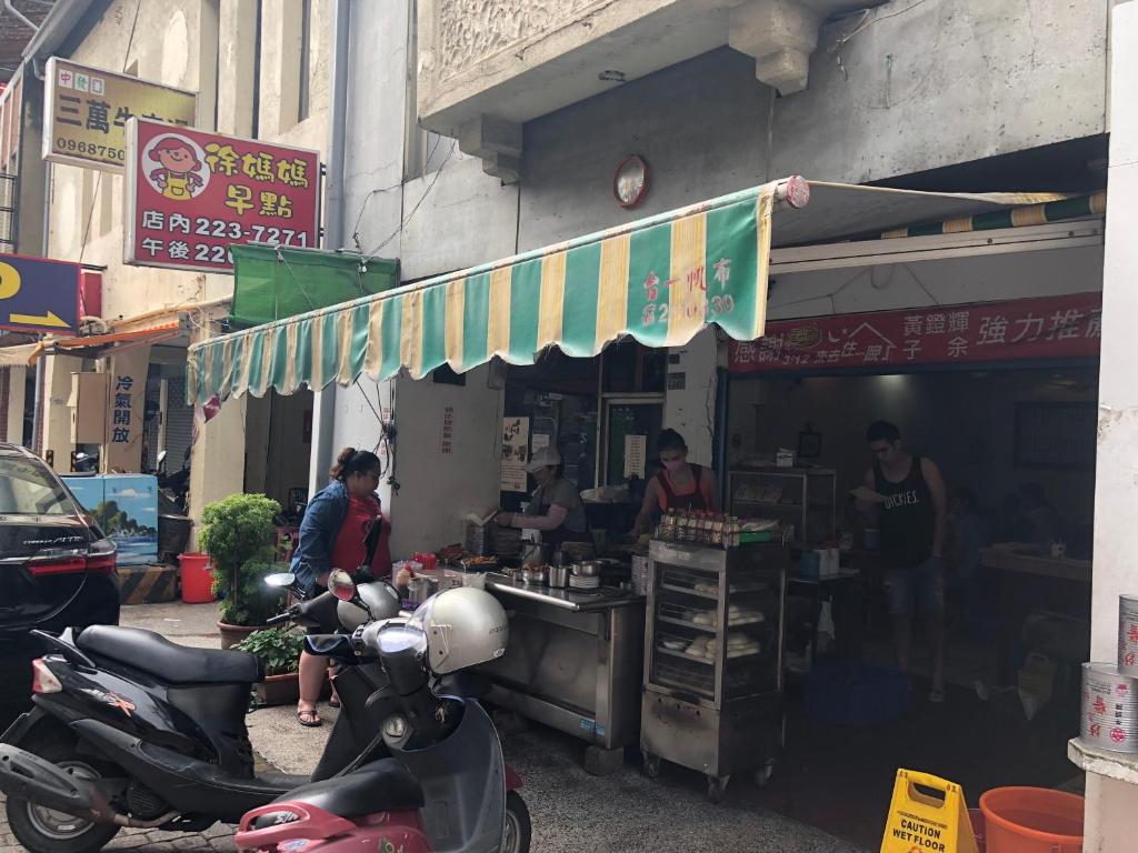 a scooter parked in front of a food stand at The Prince Hotel in Tainan