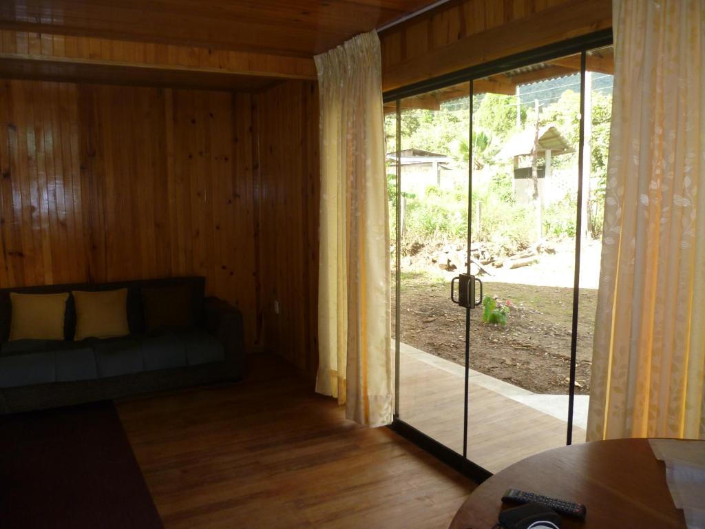 sala de estar con sofá y puerta corredera de cristal en HOSPEDAJE CAMPOS ELÌSEOS, en Oxapampa