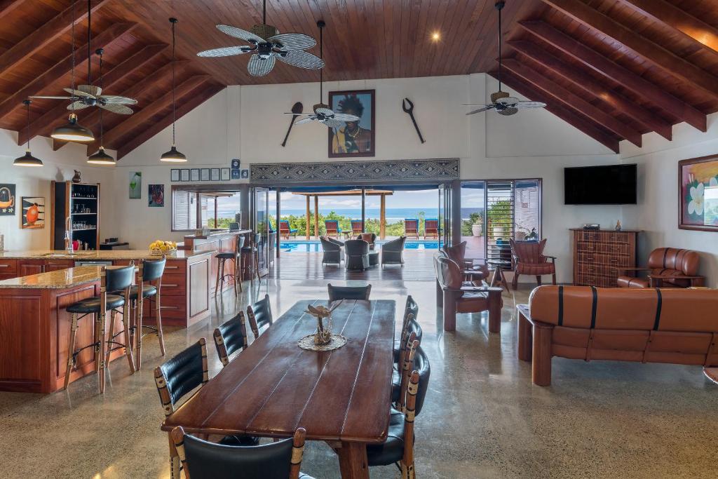 sala de estar con mesa de madera y sillas en Sea Winds Villa, en Sigatoka