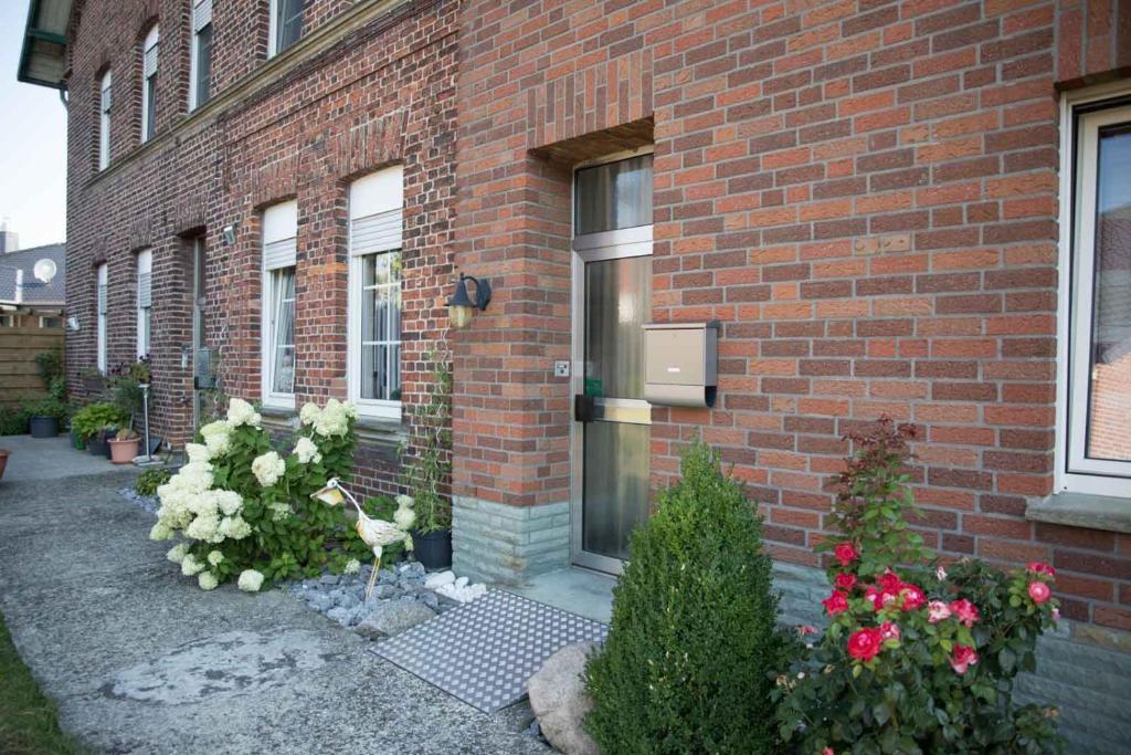 a brick building with flowers and a bird in front of a door at Ländlich zentrale Ferienwohnung in Lippetal