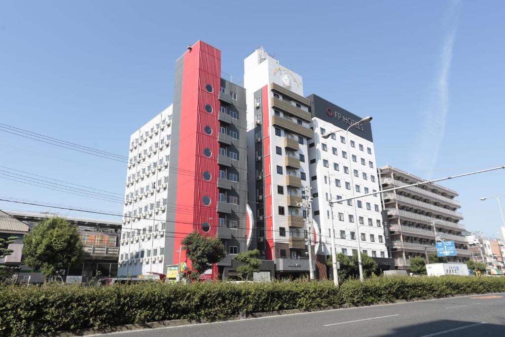 un edificio alto rojo al lado de una calle en Hotel Sunplaza 2 Annex, en Osaka