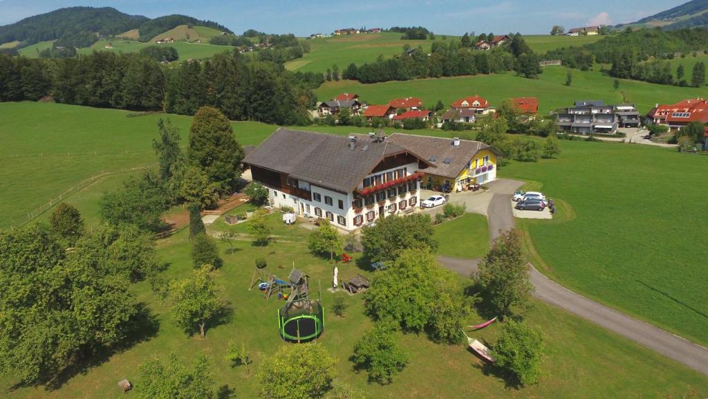 an aerial view of a large house on a green field at Ferienhof HINTERSTRASSER in Mondsee