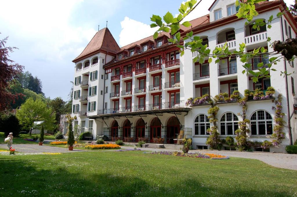 a large building with a green lawn in front of it at Mattenhof Resort in Interlaken