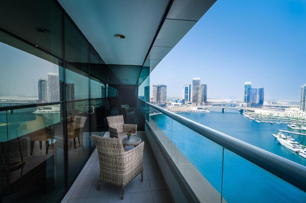 a balcony with chairs and a view of the water at Waterfront One Bedroom Downtown in Dubai