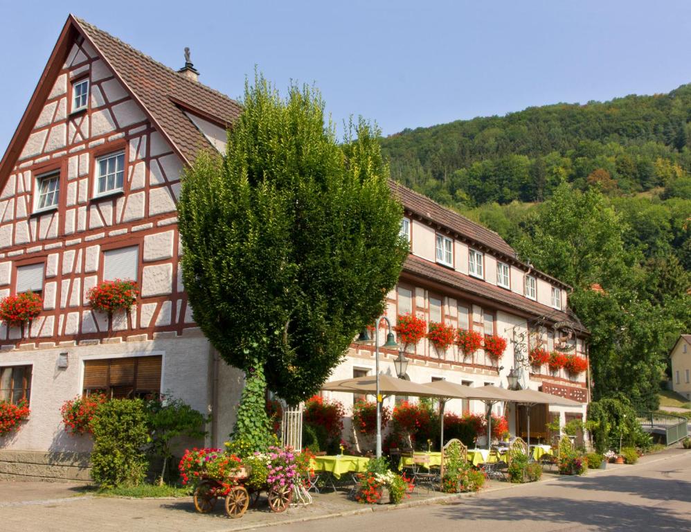 a building with a tree in front of it at Gasthof Restaurant Hirsch in Bad Ditzenbach