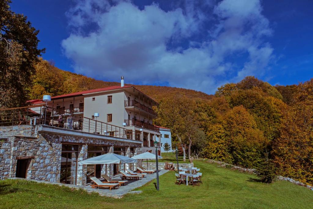 a hotel with chairs and umbrellas in the grass at Manthos Mountain Resort & Spa in Chania