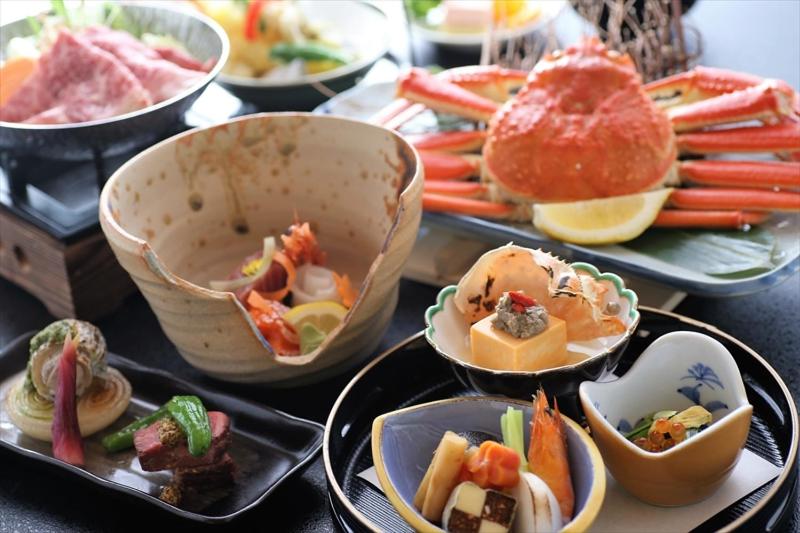 a table with plates of food and bowls of food at OkutsuHotSpa IkedayaKajikaen in Kagamino