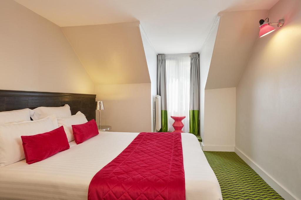 - une chambre avec un grand lit et des oreillers rouges dans l'établissement Hotel Antin Trinité, à Paris