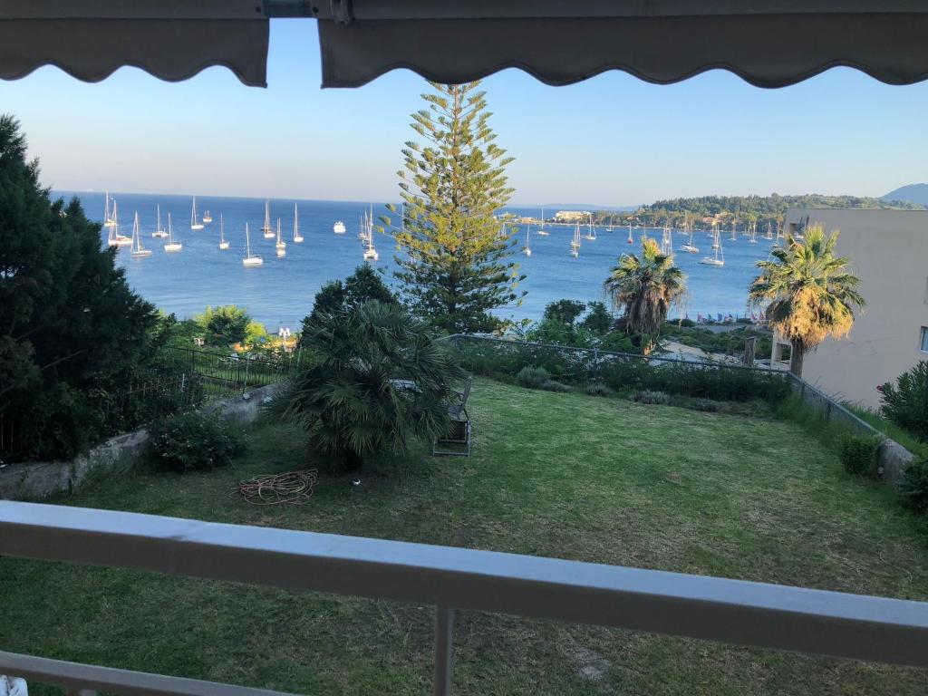 a balcony with a view of the water and boats at Classy lux apt w/ sea view, garden, parking in Corfu