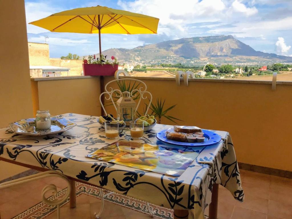 einen Tisch mit einem Teller Essen und einem Regenschirm in der Unterkunft Ai Limoni in Paceco