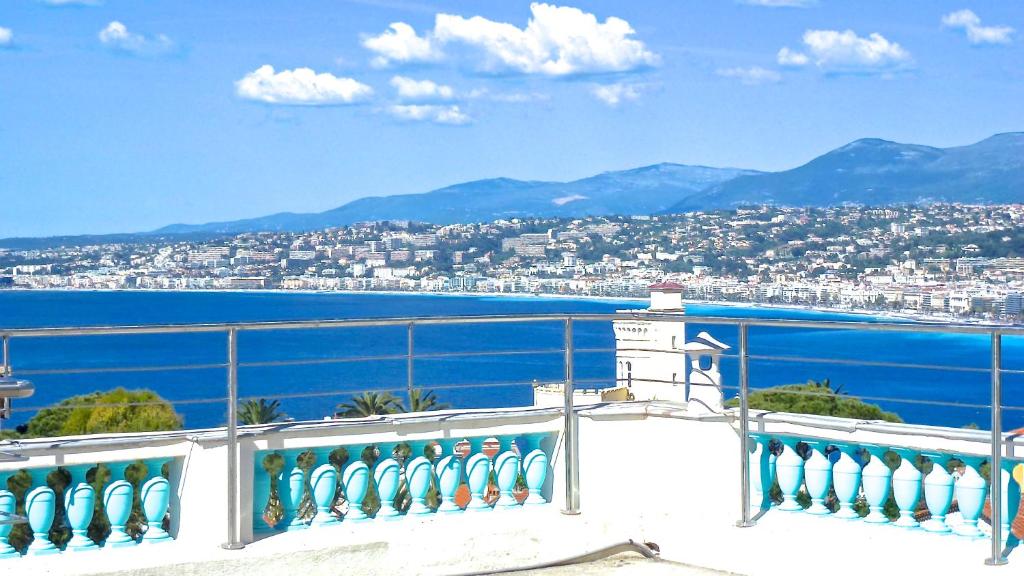 einen Balkon mit Blick auf die Stadt und das Wasser in der Unterkunft Villa Dracoena in Nizza
