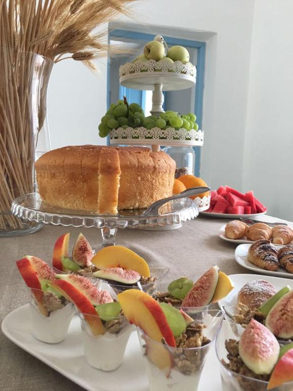 a table topped with different types of fruit and a cake at Il Borghetto Resort & Spa in Tropea