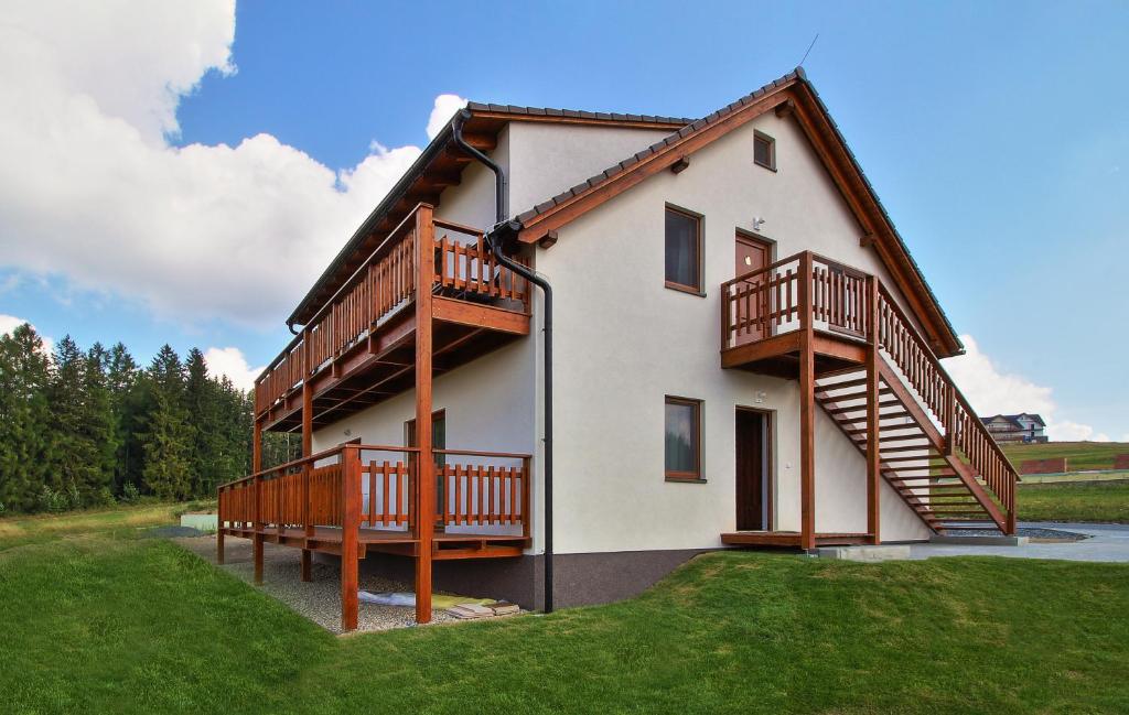 a large house with wooden balconies on the side of it at Apartmány Tlustý svišť in Vaclavov u Bruntalu