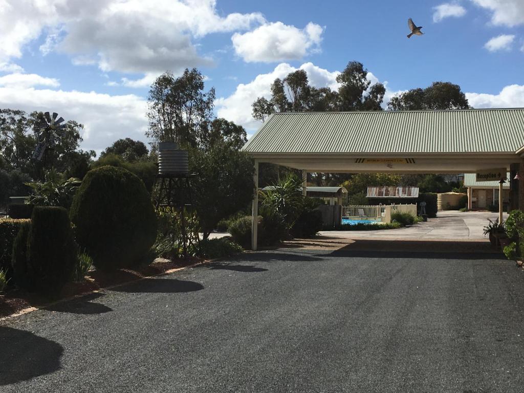 eine Straße vor einer Tankstelle mit einem Gebäude in der Unterkunft Tuckerbox Motor Inn in Gundagai