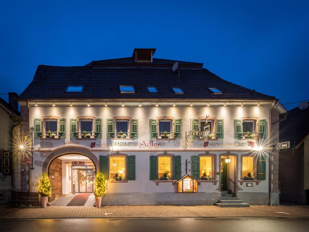 ein großes weißes Gebäude mit grünen Fensterläden in der Unterkunft Gasthaus Hotel Adler in Endingen