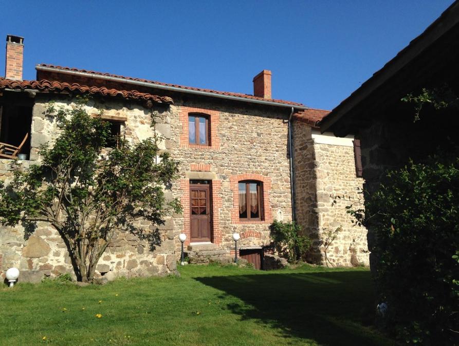 an old stone house with a tree in the yard at Gite de l'Elevage de la Mûre in Saint-Rambert-sur-Loire