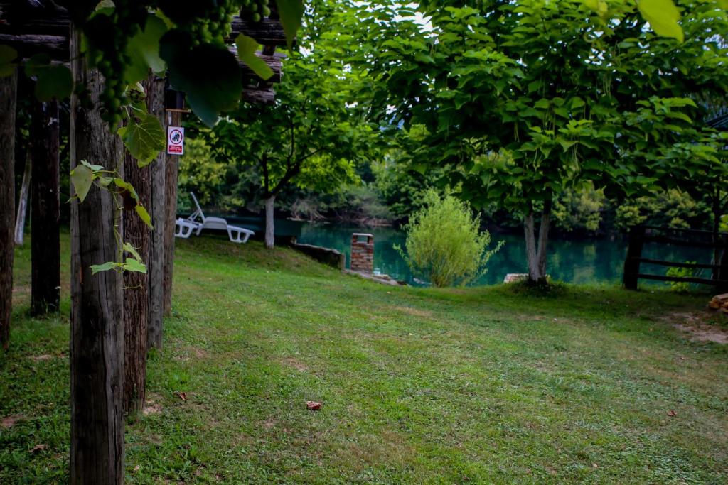 a park with a bench and a fence and trees at Apartments River Una 5 in Bihać