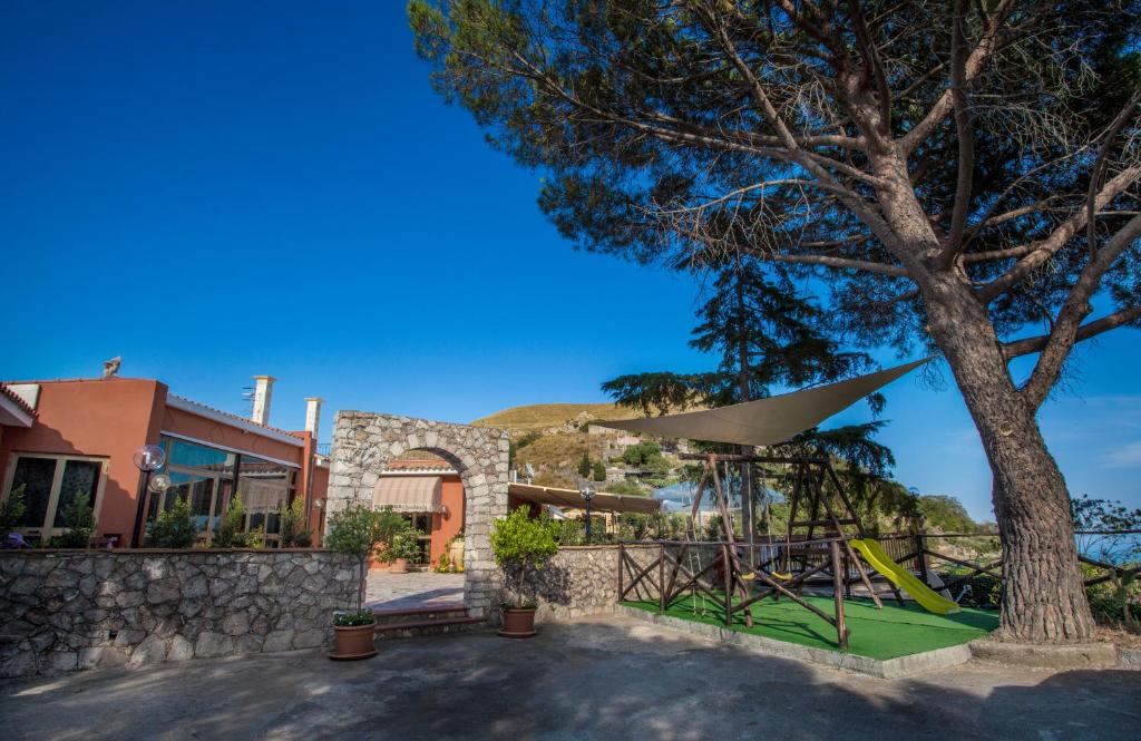 a playground with a tree and a building at Venere B&B Castelmola in Castelmola