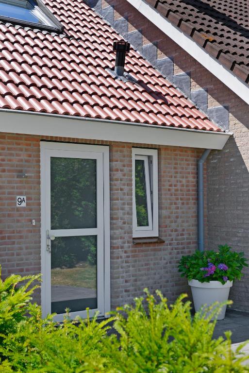 a brick house with a door and two windows at IRISLAAN 9 in Oostkapelle
