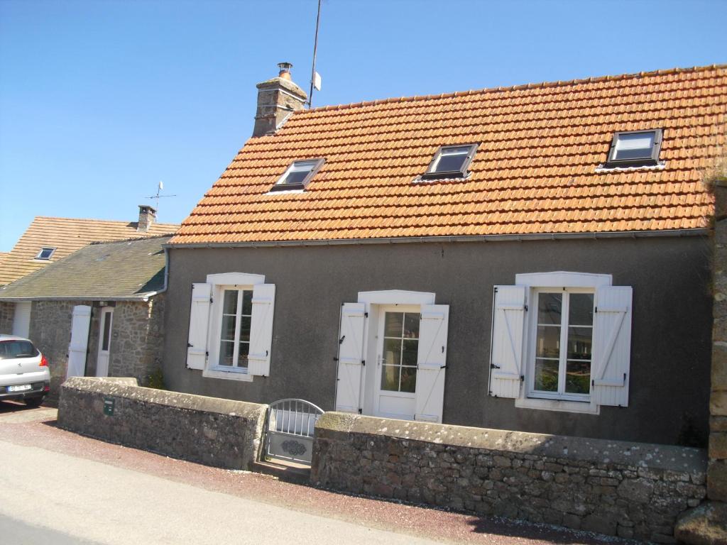 a black house with an orange roof at Vacances à Réthoville in Réthôville