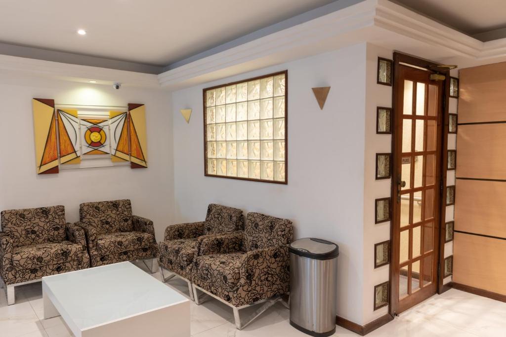 a living room with two chairs and a window at Hotel Plaza Campo Grande in Salvador