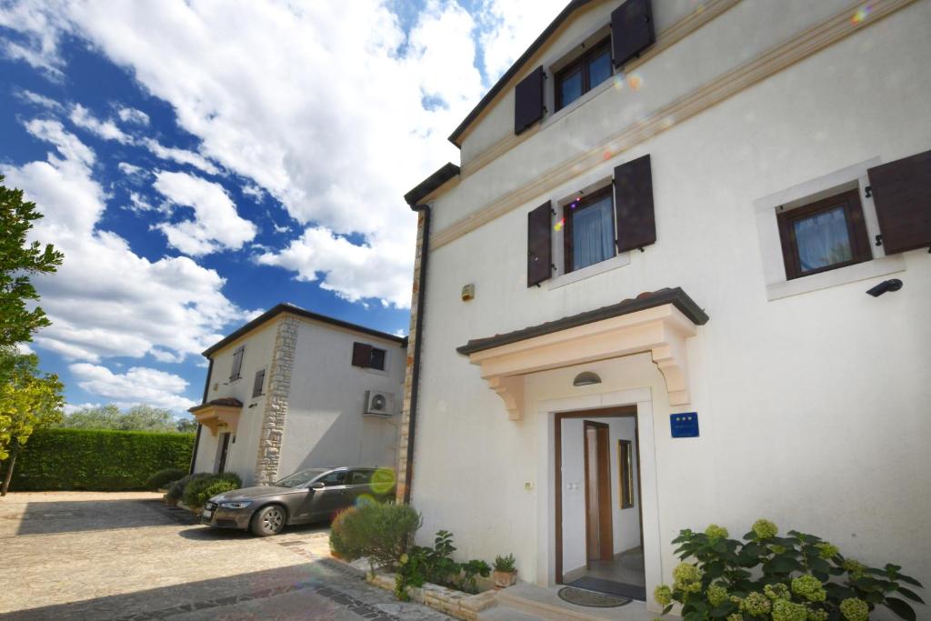 a car parked in front of a white building at Villa Svetlana in Vabriga