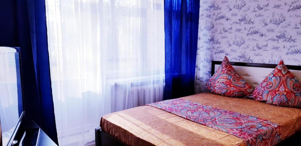 モスクワにあるАпартаменты Серпуховскаяのベッドルーム1室(青いカーテン、窓付)