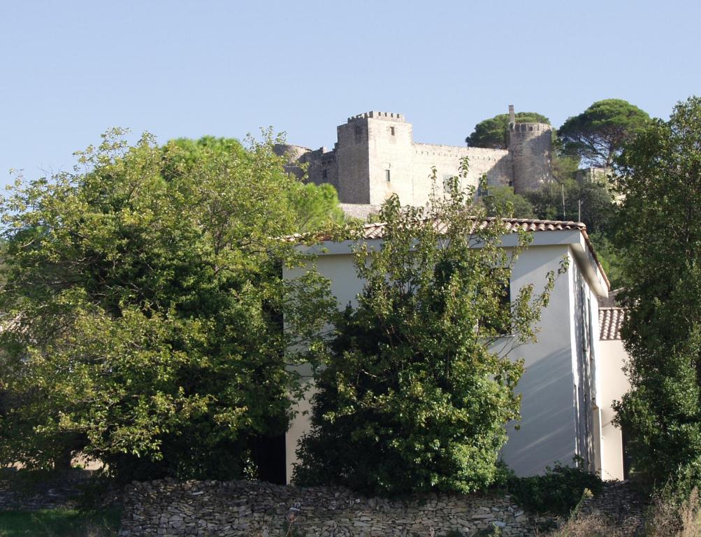 een wit huis met een kasteel op de achtergrond bij Gîte La Capitelle in Boissières
