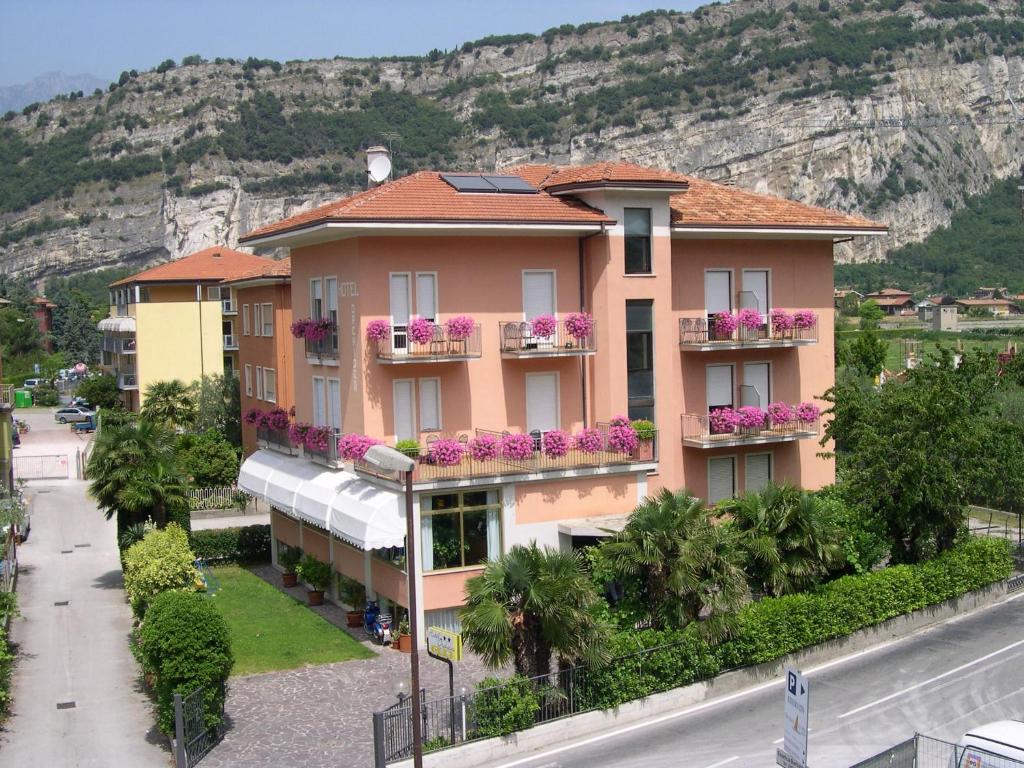 a building with flowers on the balconies in front of a mountain at Villa Orchidea in Nago-Torbole