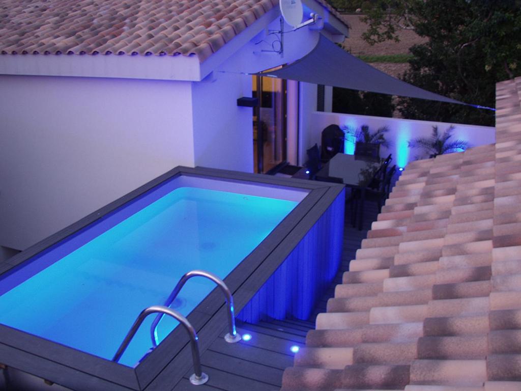 a swimming pool next to a house with a staircase at Gîte Les Clapas in Boissières