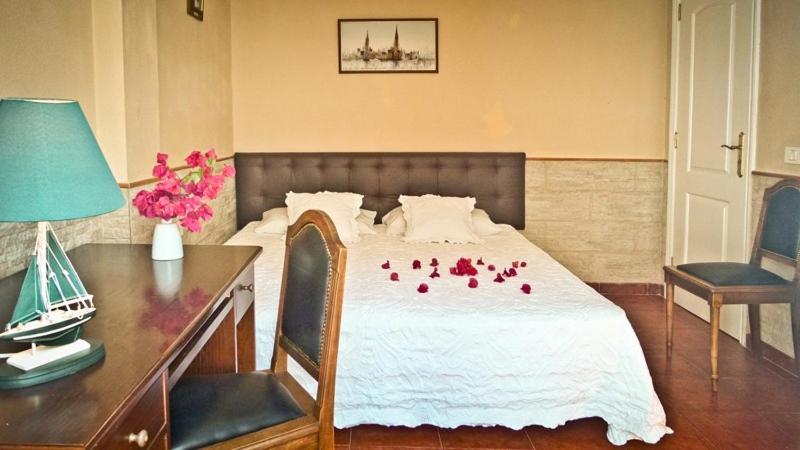 Un dormitorio con una cama con rosas rojas. en Casa Buganvilla en Los Realejos