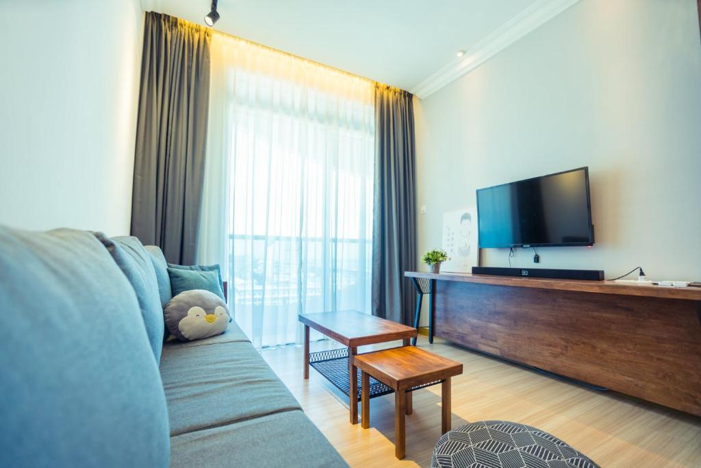 a living room with a couch and a flat screen tv at ExcluSuites Malacca @ The Wave Residence in Malacca