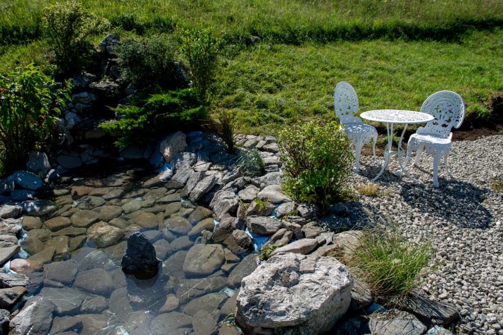 a garden with a table and two chairs and a rock path at Casa Din Gradina Lui Ioan in Tărlungeni