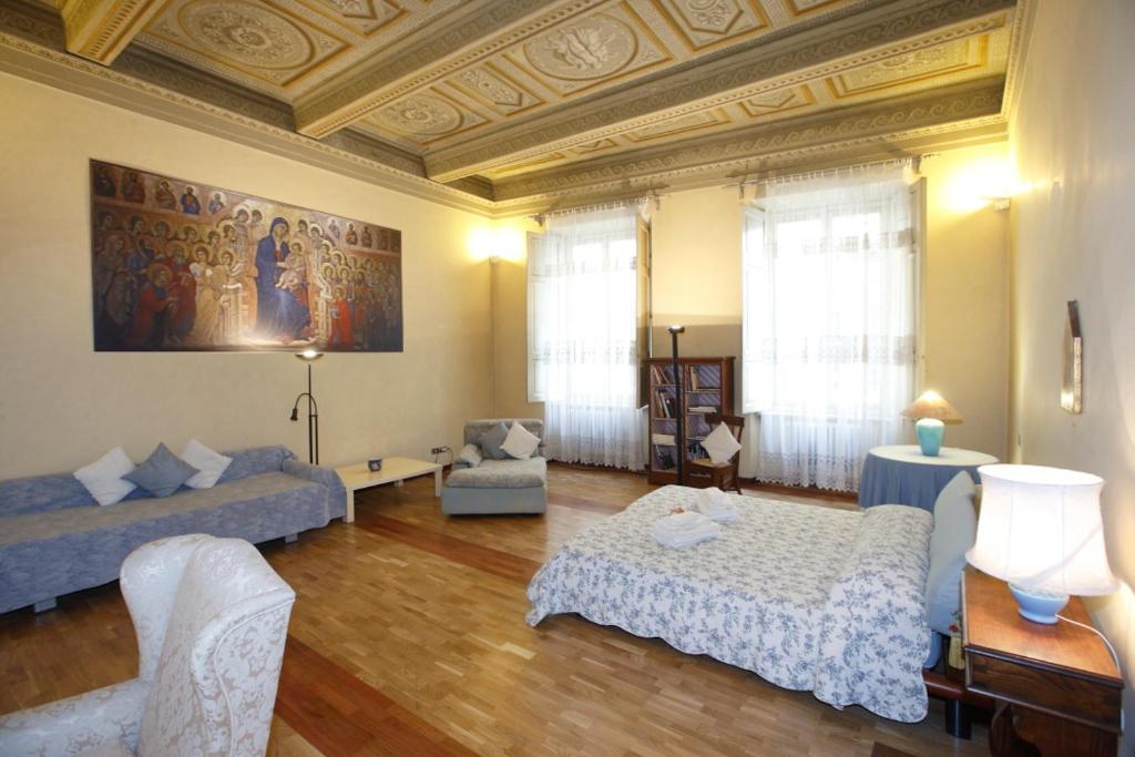 un ampio soggiorno con soffitti a cassettoni e un soggiorno con due letti di Residenza d'Epoca Montanini a Siena
