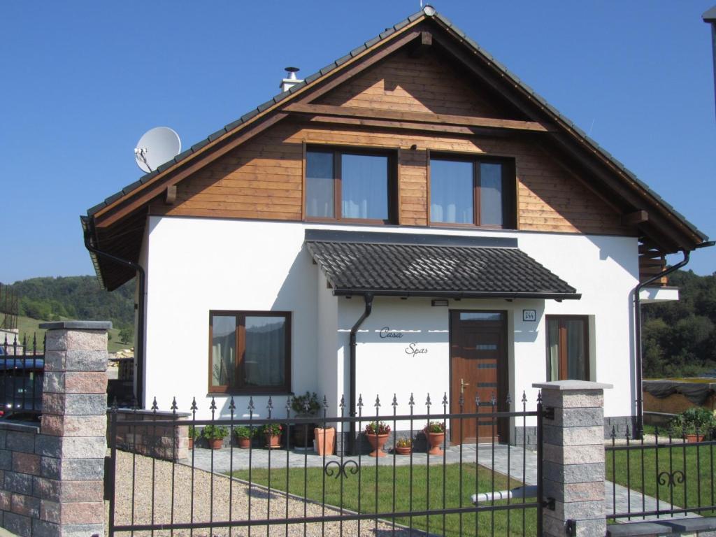 a house with a black fence in front of it at Casa Spas in Horná Mičiná