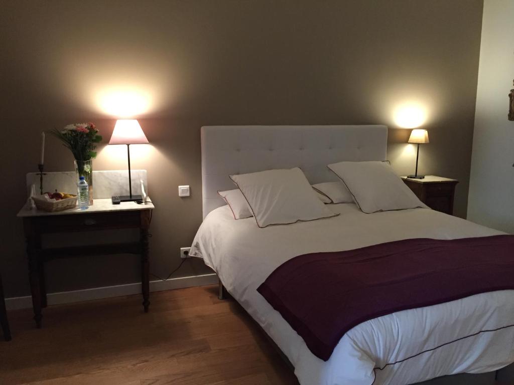 1 dormitorio con 1 cama grande y 2 lámparas en Chambres Ambroisie, en Gueytes-et-Labastide