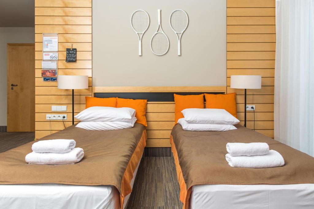 波茲南的住宿－Hotel Restauracja Tenis Kortowo，客房内的两张床和毛巾