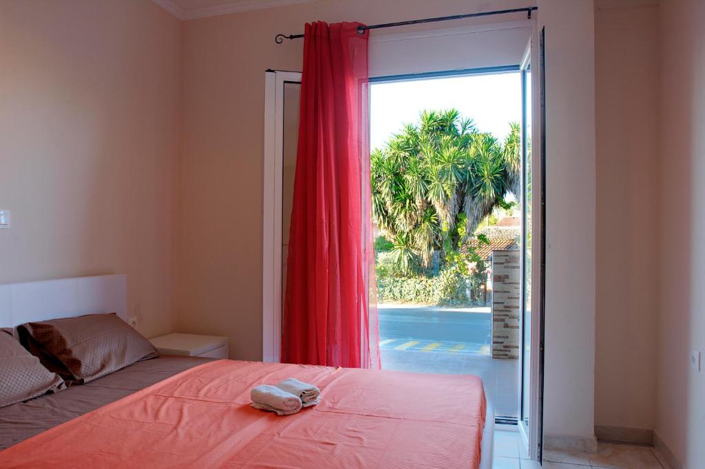 a bedroom with a bed and a sliding glass door at Spiridoula's Apartments Corfu in Perama