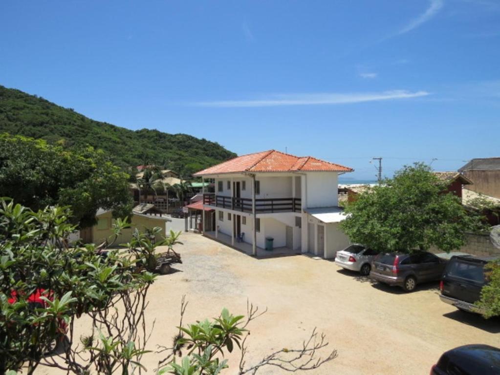 a house with a car parked in a driveway at Pousada da Bila in Guarda do Embaú