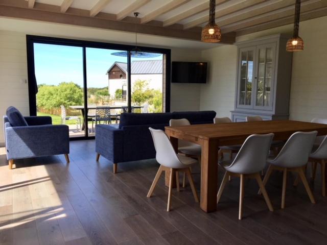 - un salon avec une table et des chaises en bois dans l'établissement Villa Mané Lann Maison d'hôtes & spa, à Carnac