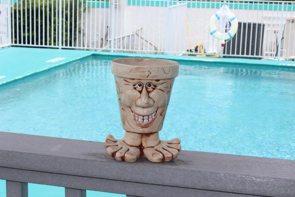 a statue of a face on a table next to a pool at The BoatHouse in Marco Island