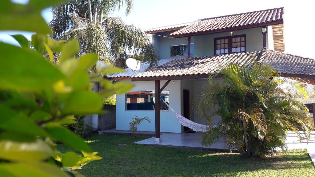 a house with a hammock in front of it at Aconchego em Floripa in Florianópolis