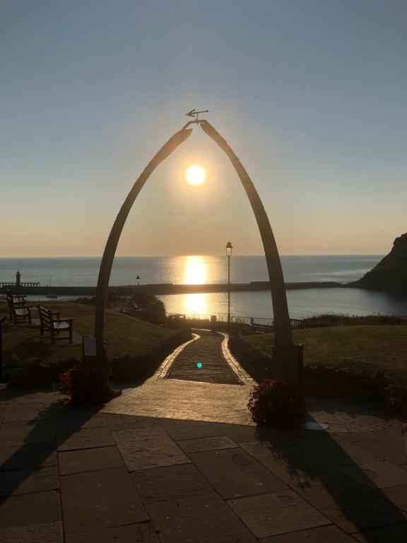 an arch with the sun rising over the ocean at Lavinia House in Whitby