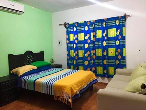 a bedroom with a bed and a couch at La cabañita in Tuxtla Gutiérrez