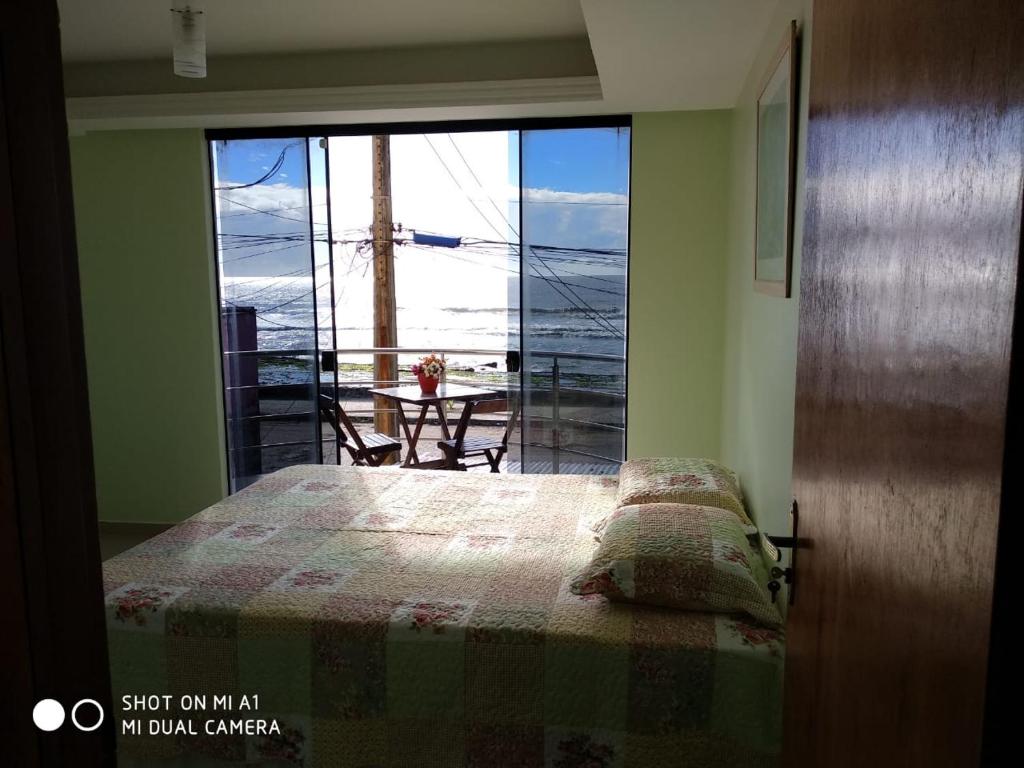 1 dormitorio con cama y vistas al océano en VENTO E SAL - Apartamento MAR, en Ilhéus