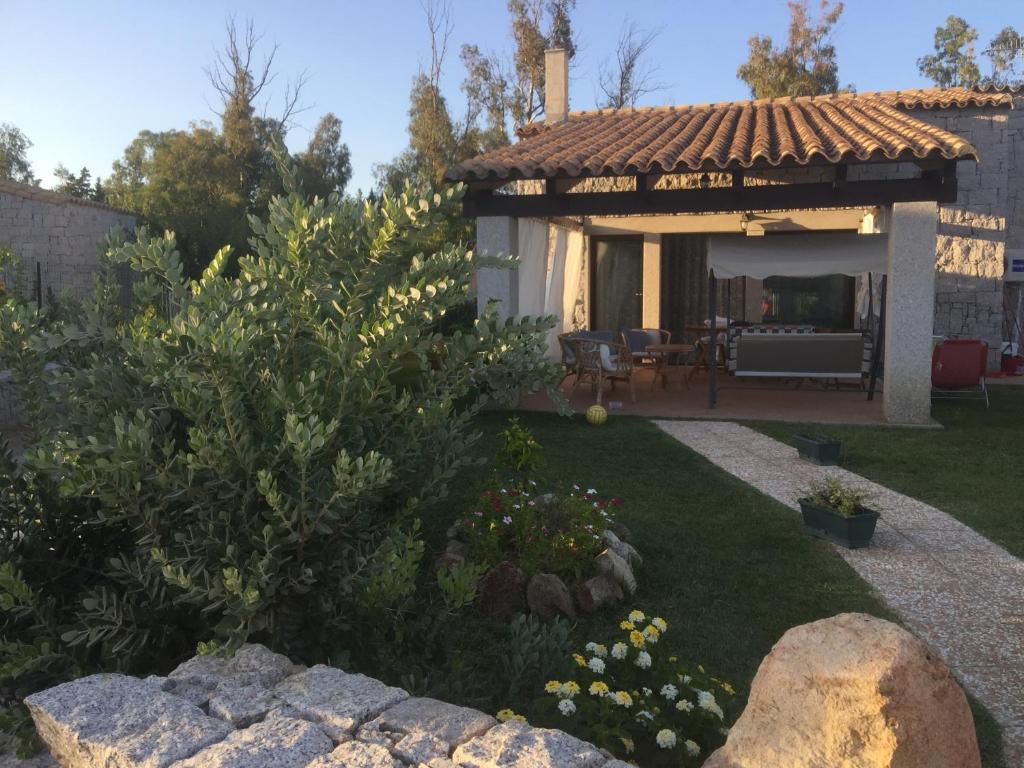 un jardín con una casa con patio en Villetta Fiori, en Castiadas