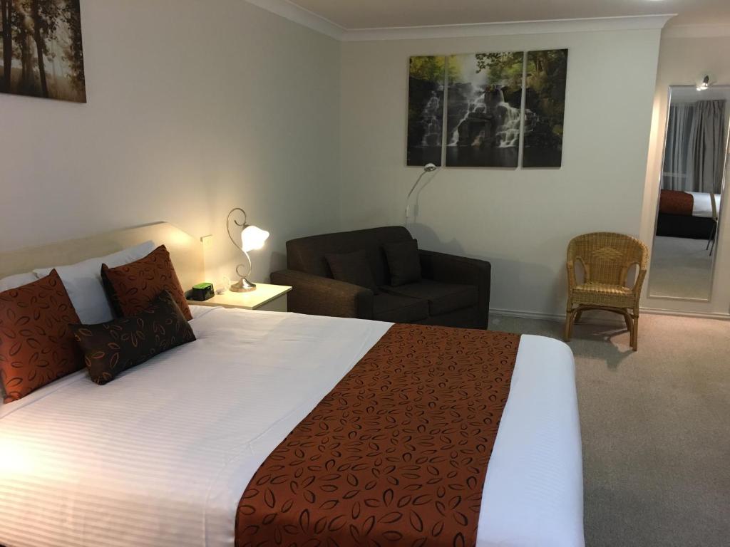 a hotel room with a bed and a desk at Tuckerbox Motor Inn in Gundagai