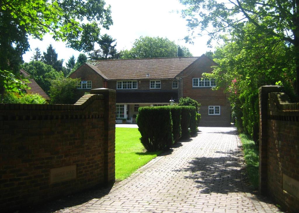 a brick fence in front of a house at Tanglewood Gatwick Bed & Breakfast in Crawley